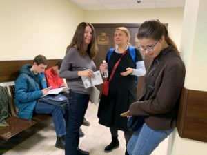 W oczekiwaniu na sprawę sądową. Wolontariusze i obserwatorzy czekają na korytarzu.